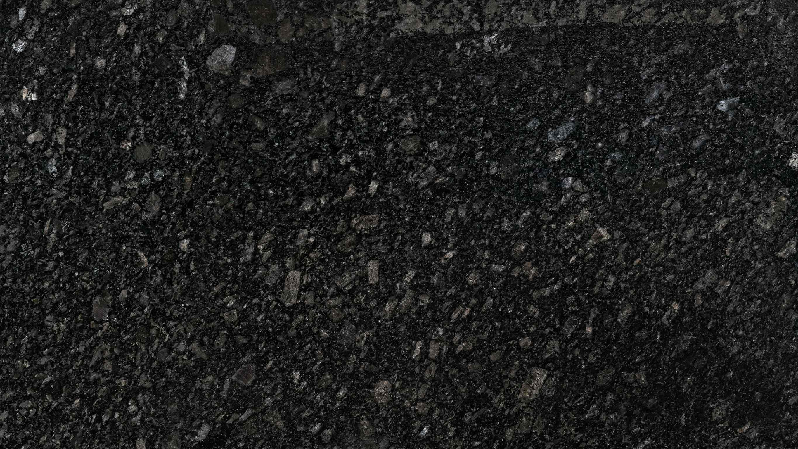 Premium Marquino Black Lapatro Indian Granite featuring a deep black canvas with a sophisticated leathered finish. High-quality polished slab supplied wholesale in Kishangarh.