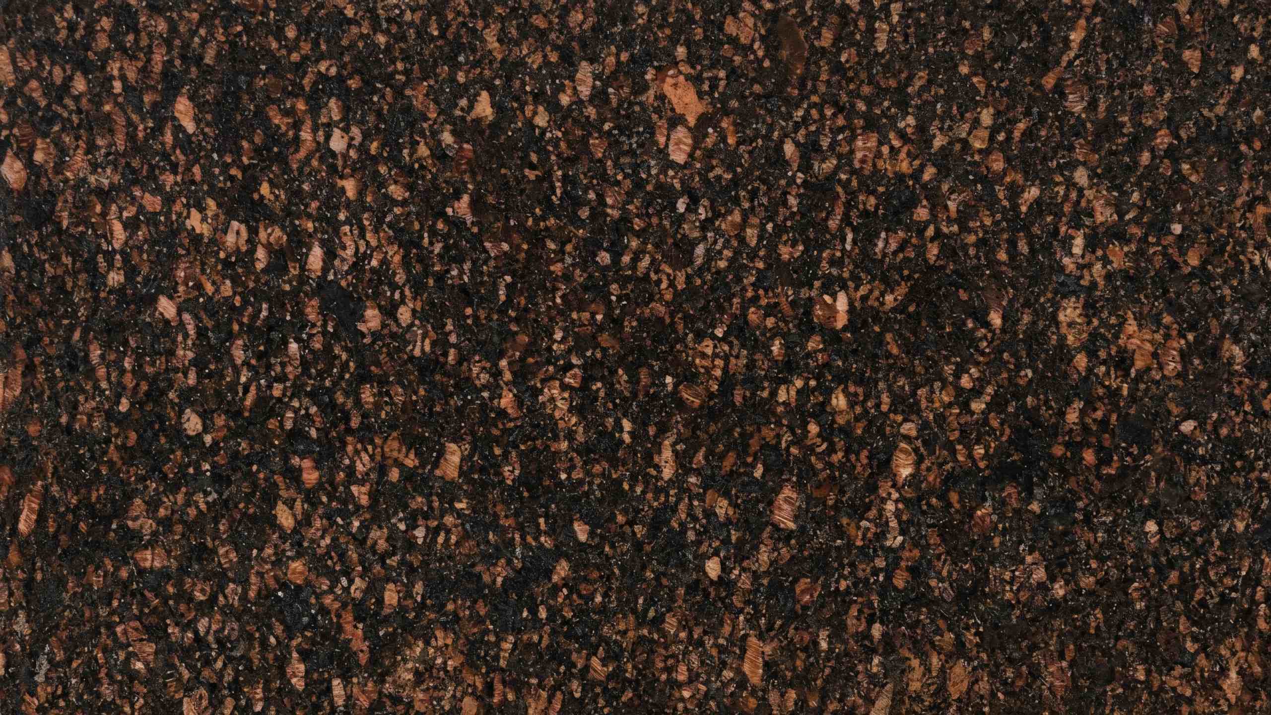 Premium Tan Brown Indian Granite featuring striking black and brown crystals combined in an earthy, robust surface. High-quality polished slab supplied wholesale in Kishangarh.